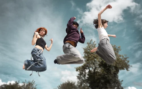 trois ados sautent devant le ciel