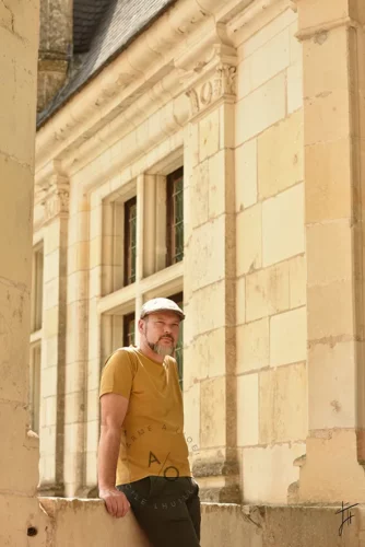 homme appuyé sur une margelle au chateau de Chambord, lumière ensoleillée