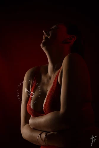 femme qui éclate de rire en lingerie rouge