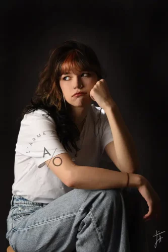 photo studio fond noir d'une jeune fille boudeuse