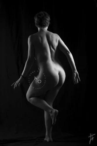femme nue de dos qui danse en noir et blanc, lumière de studio artistique