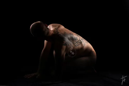 photo en studio d'un homme tatoué sur le dos, lumière artistique