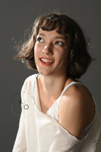 ado en photo fond gris sourire