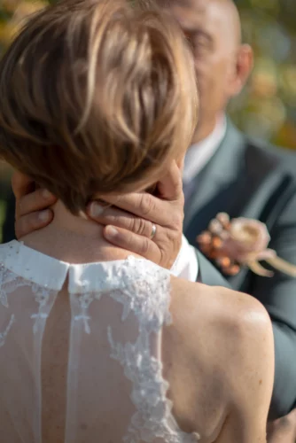 mains du marié sur le cou